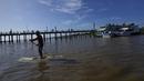 <p>Seorang peselancar mendayung untuk menaiki gelombang pasang surut yang dikenal sebagai Pororoca saat Festival Selancar Amazon yang diadakan di Canal do Perigoso atau Saluran Berbahaya di muara Sungai Amazon dekat Chaves, Pulau Marajo, Negara Bagian Para, Brasil, Senin (5/6/2023). (AP Photo/Eraldo Peres)</p>