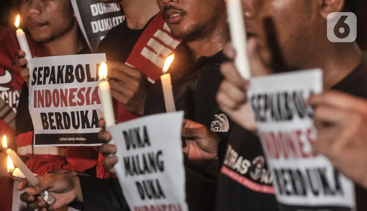 Massa yang tergabung dalam Ultras Garuda Jakarta mengikuti aksi menyalakan lilin dan tabur bunga untuk korban kerusuhan Stadion Kanjuruhan Malang di depan Stadion Gelora Bung Karno (GBK), Jakarta, Minggu (2/10/2022). Aksi tersebut sebagai aksi solidaritas antar suporter dan bentuk keprihatinan atas tragedi kerusuhan suporter sepak bola di Stadion Kanjuruhan Malang. (merdeka.com/Iqbal S Nugroho)