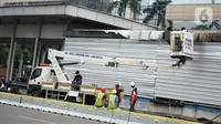 Pekerja menyelesaikan perbaikan halte-halte bus transjakarta koridor I yang rusak akibat dibakar massa saat unjuk rasa menolak UU Omnibus Law di Jakarta, Minggu (11/10/2020). Halte-halte tersebut rencananya beroperasi kembali pada Senin (12/10/2020). (Liputan6.com/Immanuel Antonius)