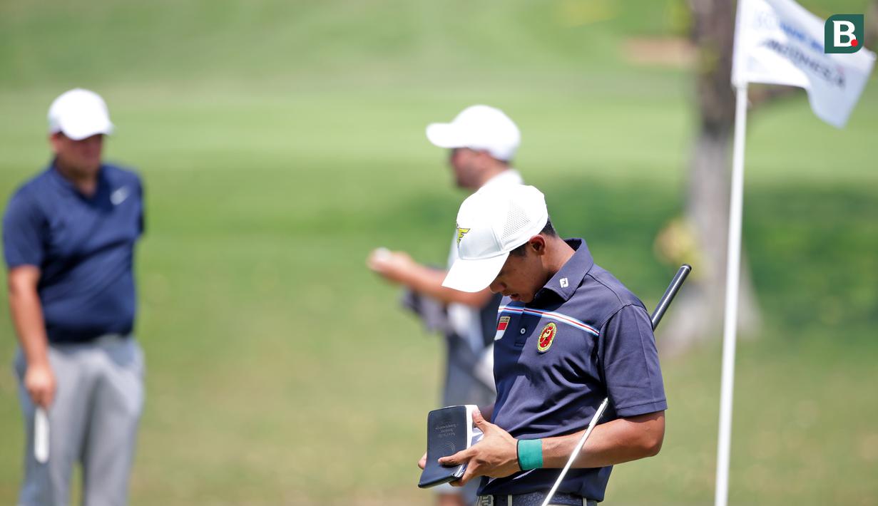 Naraajie Emerald Ramadhan Putra pegolf amatir putra Indonesia mengecek catatannya sebelum melakukan pukulan pada turnamen golf profesional BRI Indonesia Open 2019, Sabtu di Lapangan Golf Pondok Indah Jakarta, Sabtu (31/8/2019). (Bola.com/Peksi Cahyo)