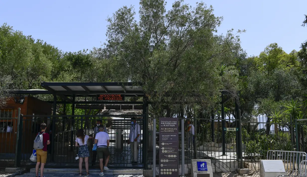 Turis berbicara dengan staf Acropolis kuno, di Athena Yunani, Selasa (3/8/2021). Pihak berwenang di Yunani telah menutup Acropolis dan situs kuno lainnya karena gelombang panas yang membakar Mediterania timur terus memburuk. (AP Photo/Michael Varaklas)