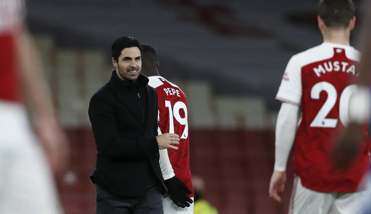 Pelatih Arsenal, Mikel Arteta tersenyum saat berjalan memberi selamat kepada para pemainnya setelah pertandingan melawan Chelsea pada pertandigan lanjutan Liga Inggris di Stadion Emirates di London, Minggu (27/12/2020). Arsenal sukses mengalahkan Chelsea 3-1. (Adrian Dennis / Pool via AP)