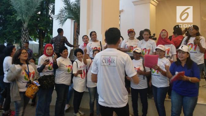 Pendukung Jokowi bernyanyi di depan lokasi debat kedua capres di Hotel Sultan. (Liputan6.com/Delvira Hutabarat)