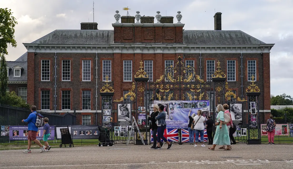 Orang-orang melihat potret Putri Diana yang dipajang di luar gerbang Istana Kensington, di London, Senin, 29 Agustus 2022. Minggu ini, tepatnya pada 31 Agustus, menandai peringatan 25 tahun kematian Putri Diana dalam kecelakaan mobil di Paris. (AP Photo/Alberto Pezzali)