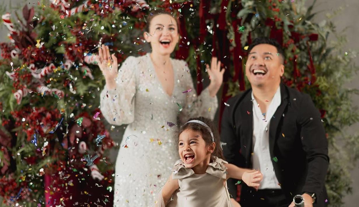 Jalani pemotretan bertema Natal, kebahagiaan terpancar jelas di wajah Rianti Cartwright, Cassanova Alfonso dan si kecil Cara Rose ketika confetti dilemparkan. di tengah hujan confetti. Dekorasi ruang pemotretan ini sangat simpel dengan Pohon Natal. Meski dekorasinya sangat simpel, namun kehangatan keluarga pasangan artis yang menikah pada tahun 2010 ini penuh kehangatan. (Liputan6.com/IG/@riantic)