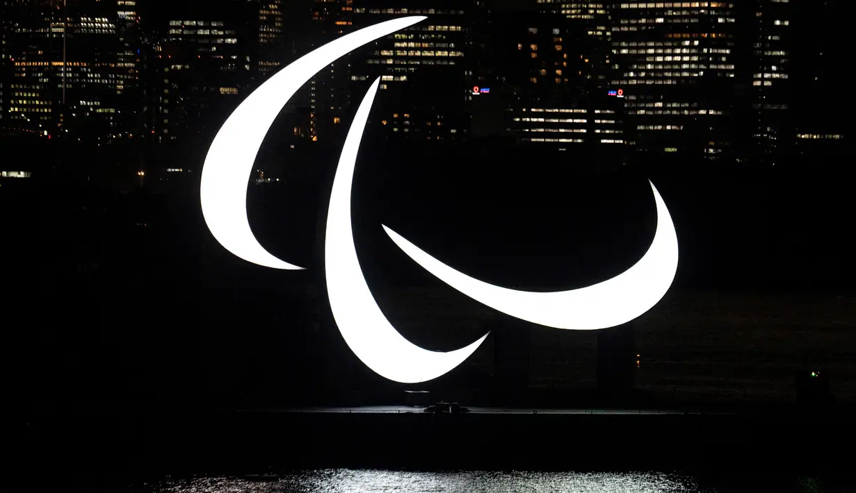Simbol Paralimpiade terlihat menyala pada malam hari di tepi Pantai Odaiba, Tokyo, Jepang, 23 Agustus 2021. Paralimpiade Tokyo 2020 mulai 24 Agustus 2021 sampai 5 September 2021. (Charly TRIBALLEAU/AFP)