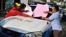 Karyawan Hotel Alexis menempelkan poster tuntutan di mobil Satpol PP saat unjuk rasa di Jakarta Utara, Kamis (29/3). Penutupan terkait kasus dugaan adanya praktek prostitusi dan perdagangan manusia di hotel tersebut. (Liputan6.com/Immanuel Antonius)
