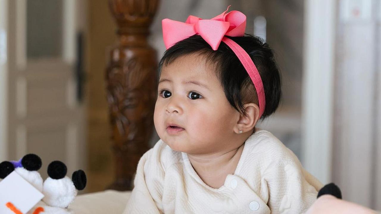 Potret Lily dengan Pita Pink di Kepala, Super Gemas Pose di Atas Kasur
