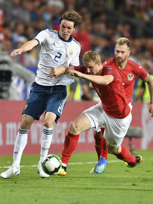 Pemain Austria, Martin Hinteregger (kanan) berebut bola dengan pemain Rusia, Mario Fernandes pada laga uji coba di Tivoli Stadium, Innsbruck, Austria, (30/5/2018). Austria menang atas Rusia 1-0. (AP/Kerstin Joensson)