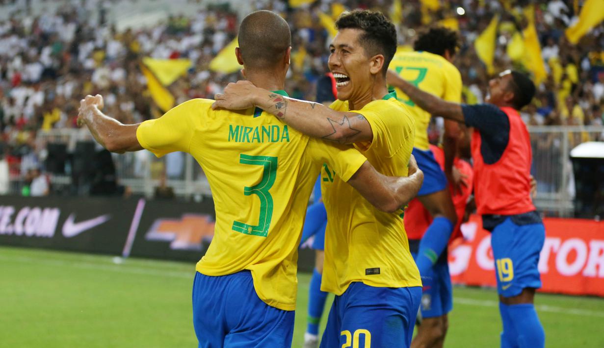 Bek Brasil, Miranda, melakukan selebrasi bersama Roberto Firmino usai membobol gawang Argentina, pada laga persahabatan di Stadion King Abdullah, Jeddah, Selasa (16/10/2018). Brasil menang 1-0 atas Argentina. (AFP/STR)