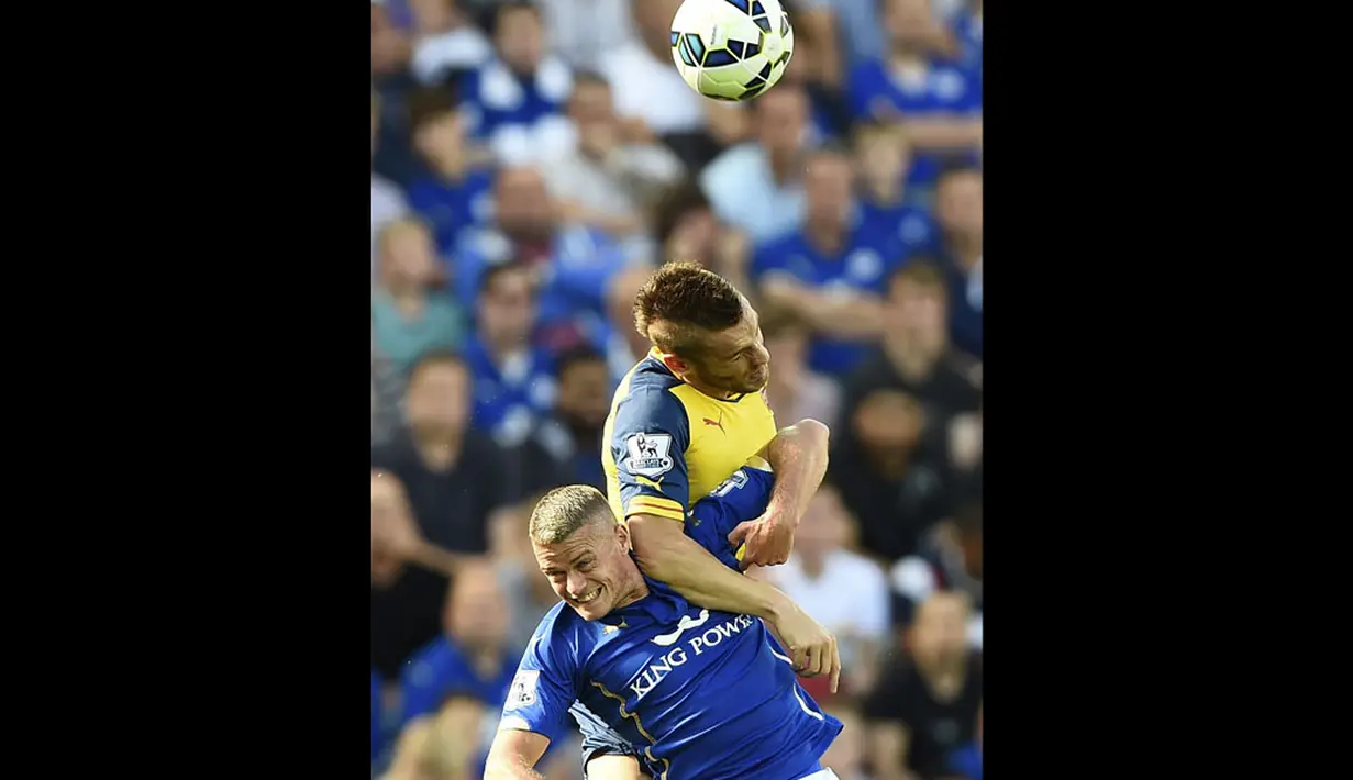 Pemain belakang Arsenal, Mathieu Debuchy (atas), berusaha memenangkan duel perebutan bola dengan bek Leicester City, Paul Konchesky, saat berlaga di lanjutan Liga Primer Inggris 2014-2015 di Stadion King Power, (31/8/2014). (REUTERS/Dylan Martinez)