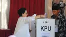 Ketua Umum PDIP yang juga Presiden kelima RI Megawati Soekarnoputri memasukkan surat suara saat menggunakan hak pilihnya pada Pemilu 2019 di TPS 62, Kebagusan, Jakarta, Rabu (17/4). Megawati mencoblos didampingi keluarganya, termasuk Puan Maharani dan Prananda Prabowo. (Liputan6.com/Angga Yuniar)