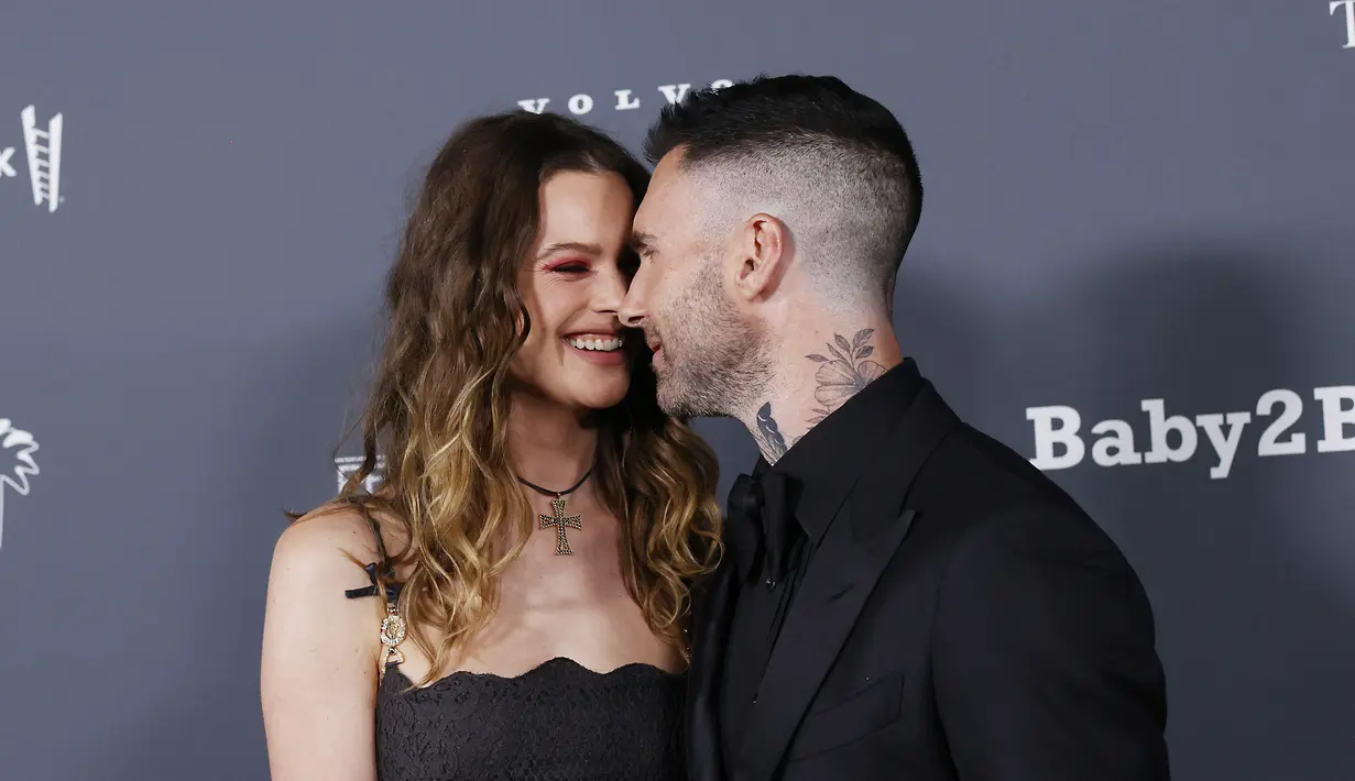 Adam Levine bersama istrinya Behati Prinsloo saat menghadiri Baby2Baby 10-Year Gala Presented By Paul Mitchell di Pacific Design Center di West Hollywood, California pada 13 November 2021. Vokalis Marron 5 tengah jadi sorotan lantaran kabar diduga berselingkuh dengan seorang  seleb TikTok bernama Sumner Stroh. (AFP/Michael Tran)