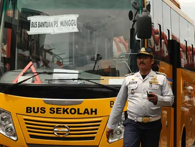 Petugas mengawal bus sekolah untuk mengangkut penumpang di Terminal Blok M Jakarta, Senin (21/12/2015). Bus sekolah dikerahkan untuk mengantisipasi penumpukan penumpang seiring mogoknya sejumlah sopir metromini. (Liputan6.com/Helmi Fithriansyah)