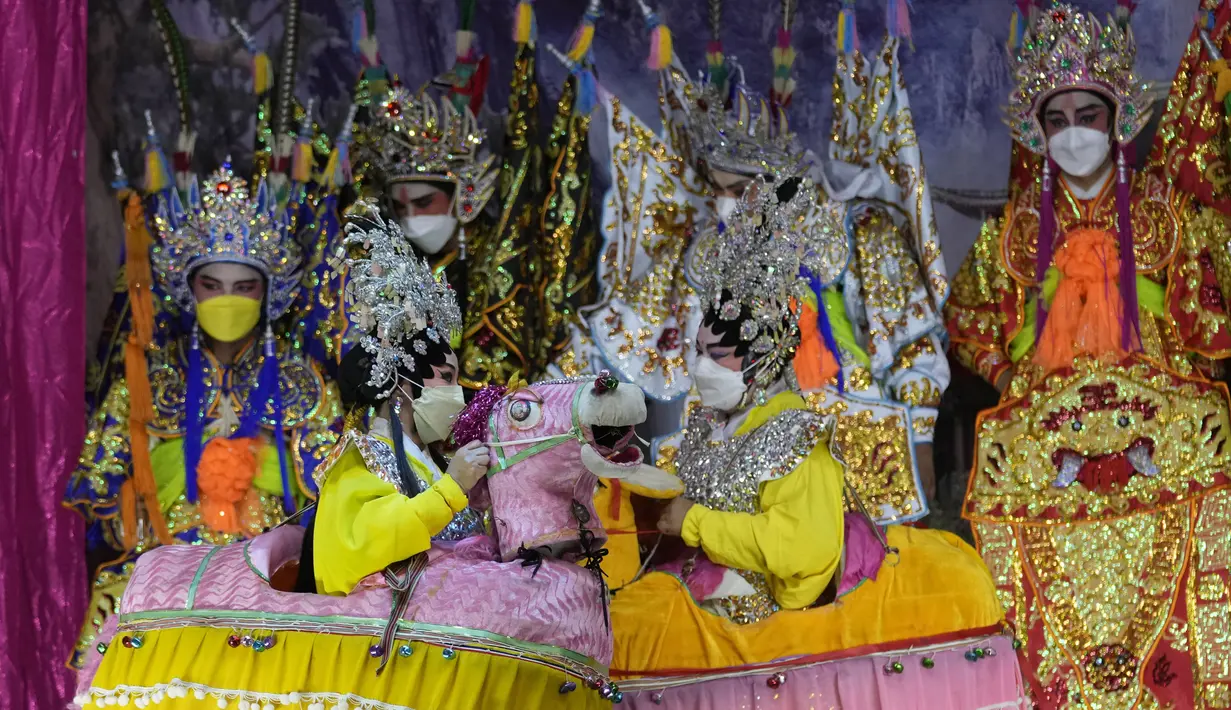 Pemain opera Tiongkok memakai masker saat tampil di atas panggung di Bangkok, Rabu (6/10/2021). Sempat vakum, pertunjukan opera Tiongkok di Thailand kembali dihidupkan meski belakangan ini kasus harian Covid-19 kembali meningkat. (AP Photo/Sakchai Lalit)
