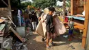 Warga dibantu petugas mengevakuasi barang saat penggusuran di kawasan TPU Menteng Pulo, Jakarta Selatan (7/4). Lebih dari seratus kepala keluarga digusur karena menempati lahan dan mendirikan bangunan di pemakaman umum. (Liputan6.com/Gempur M Surya)