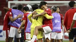Kiper Timnas Indonesia, Nadeo Argawinata yang mampu mengagalkan tendangan penalti pemain Singapura mendapat pelukan hangat dari rekannya Rizky Ridho di akhir laga. (AP/Suhaimi Abdullah)