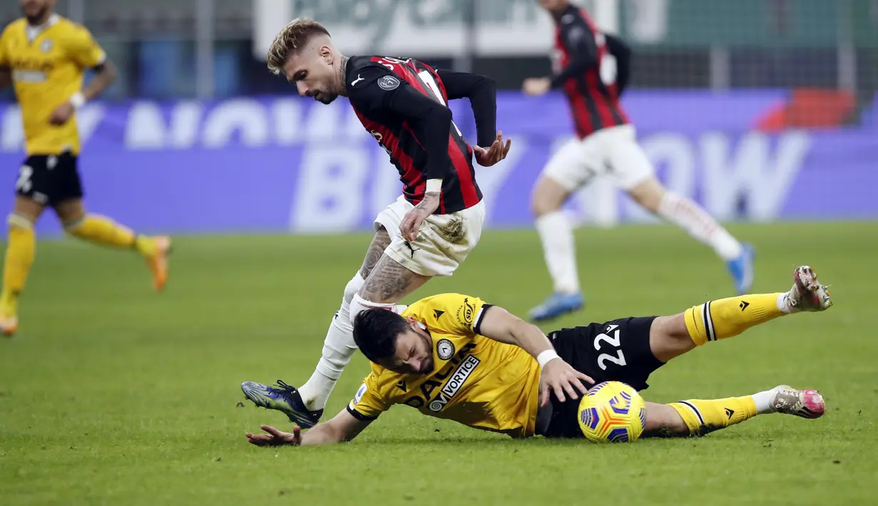 Gelandang Udinese Tolgay Arslan (22) dijatuhkan oleh penyerang AC Milan Samu Castillejo (7) saat pertandingan lanjutan Liga Serie A Italia di stadion San Siro, di Milan, Italia, Kamis (4/3/2021). Dengan hasil ini, AC Milan tetap berada di posisi kedua dengan 53 poin dari 25 laga. (AP Photo/Antonio C