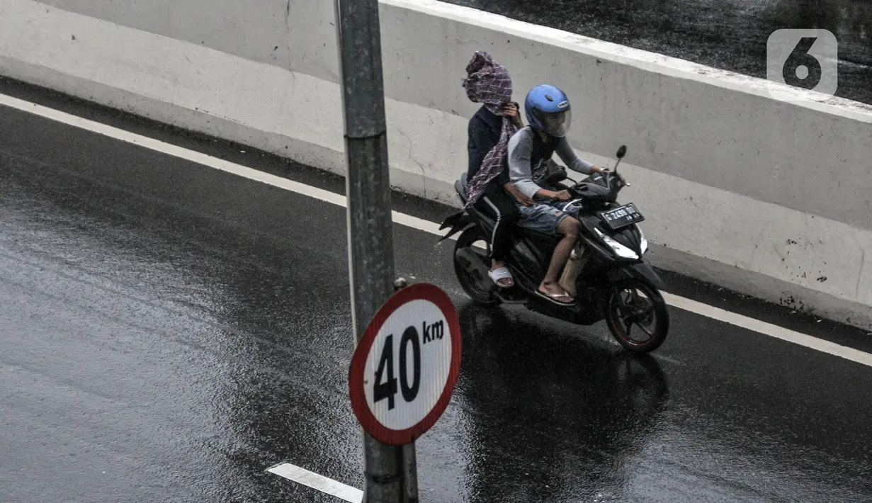 Pengendara sepeda motor menerobos Jalan Layang Non Tol (JLNT) Casablanca saat hujan, Jakarta, Minggu (20/12/2020). Aksi nekat pengendara sepeda motor tersebut dapat mengancam keselamatan diri serta pengguna jalan lain. (merdeka.com/Iqbal S. Nugroho)