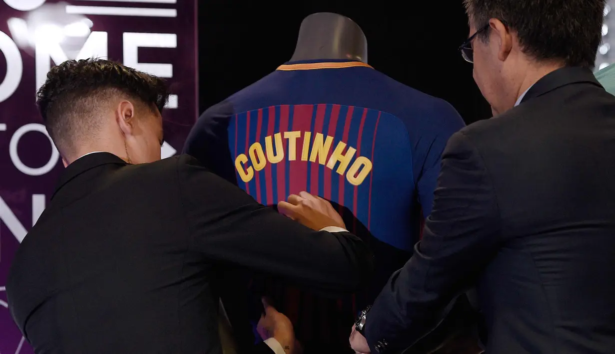Gelandang baru Brasil asal Brasil Philippe Coutinho menandatangani jersey tim barunya di Barcelona (8/1). Coutinho dikontrak Barcelona selama 5,5 tahun. (AFP Photo/Lluis Gene)