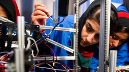 Ekspresi salah satu anggota, Liza Azizi saat memperbaiki masalah pada robot sebelum pembukaan The First Global Challenge di Washington, AS, Minggu (16/7). Bagi mereka, tahun ini adalah kompetisi tahunan robotik untuk pertama kalinya. (AP/Cliff Owen)