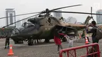 Warga berfoto berlatar helikopter TNI pada pameran Alat Utama Sistem Persenjataan TNI di Kawasan Monas, Jakarta, Kamis (27/9). Pameran ini bagian perayaan HUT TNI ke-73. (Liputan6.com/Helmi Fithriansyah)