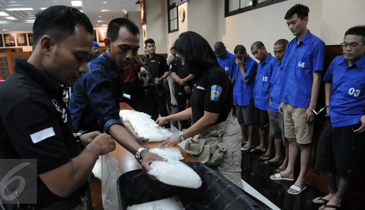 Petugas menata barang bukti saat rilis sindikat pengedar narkoba jaringan internasional di Rupatama Mabes Polri, Jakarta, Rabu (24/8). Dittipidnarkoba Bareskrim Polri mengamankan 63,1 kg narkoba jenis sabu dari 7 orang pelaku. (Liputan6.com/Helmi Afandi)