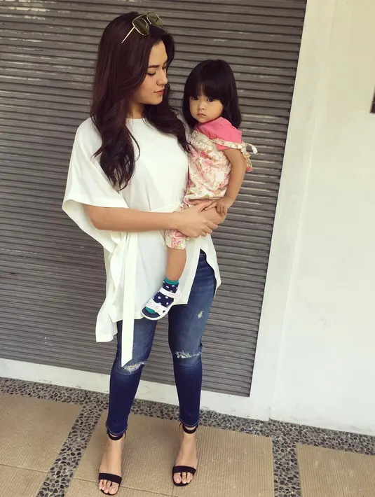 Selanjutnya, Raisa memadukan ripped jeansnya dengan blouse putih yang berpotongan asimetrik di bagian bawahnya. Sedikit terlihat formal lantaran Raisa memakai heels berwarna hitam. (Instagram/raisa6690)