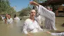 Pendeta membaptis umat Kristen di Qasr al-Yahud, Sungai Yordan, Jericho, Palestina, Jumat (13/9/2019). Area ini dulu adalah kawasan perang antara Israel dengan negara-negara Arab. (HAZEM BADER/AFP)