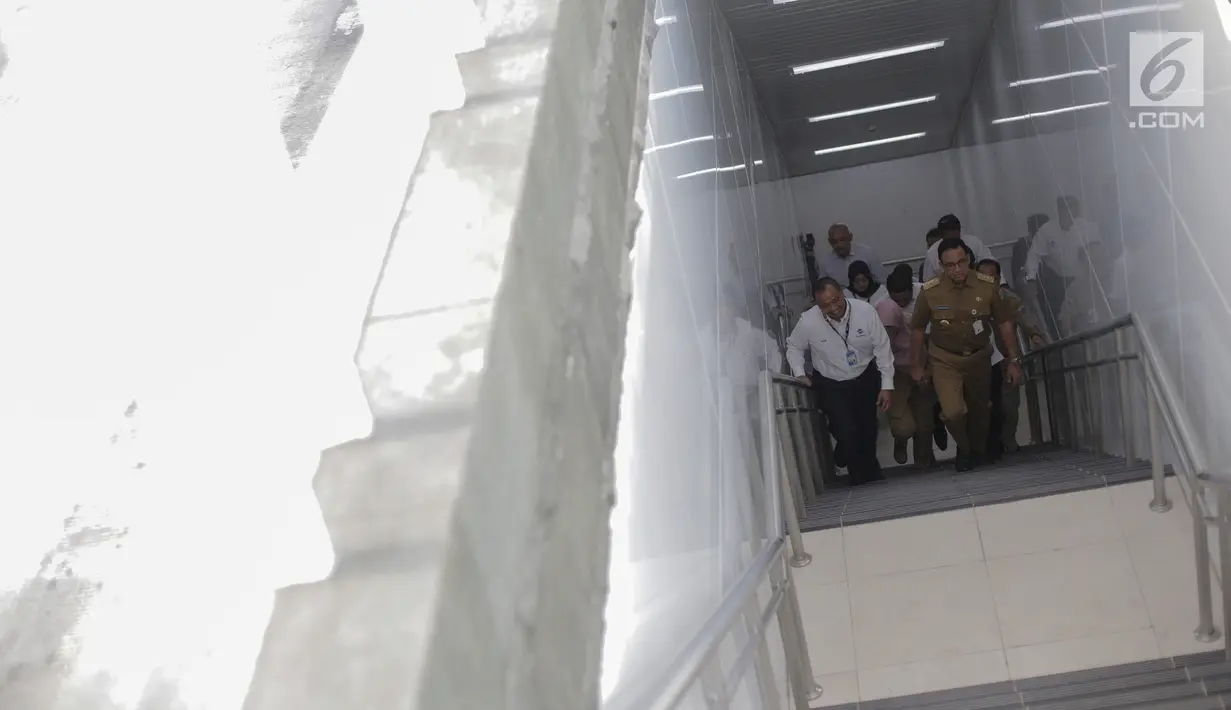 Gubernur DKI Jakarta Anies Baswedan menggunakan tangga dari stasiun moda raya terpadu (MRT) Bundaran Hotel Indonesia (HI) menuju halte transJakarta Senin (25/3). Halte TransJakarta Bundaran HI sempat dibongkar dan dinonaktifkan karena adanya proyek MRT Jakarta pada 2014. (Liputan6.com/Faizal Fanani)