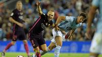 Gelandang Barcelona, Andres Iniesta (kiri) saat berduel kontra pemain Celta Vigo, Nemanja Radoja, pada lanjutan La Liga 2016-2017, di Stadion Balaidos, Senin (3/10/2016) dini hari WIB. Iniesta melakoni laga ke-600 bersama Barcelona di seluruh kompetisi.  