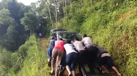 Polisi dan warga terpaksa mendorong mobil turis asal Yogyakarta terjebak di jalur sempit pegunungan Dieng, Wonosobo. (Foto: Liputan6.com/Muhamad Ridlo/Polres Wonosobo).