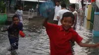 Seorang anak di Semrang Utara bermain dalam genangan rob. (foto: Liputan6.com/edhie prayitno ige)