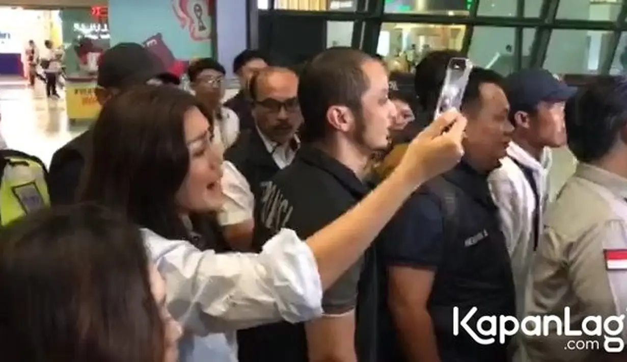 Jessica yang sejak lama emosi, juga teriak-teriak mengikuti dan merekam Steven yang digelandang petugas menuju mobil. [KapanLagi.com/Muhammad Akrom Sukarya]