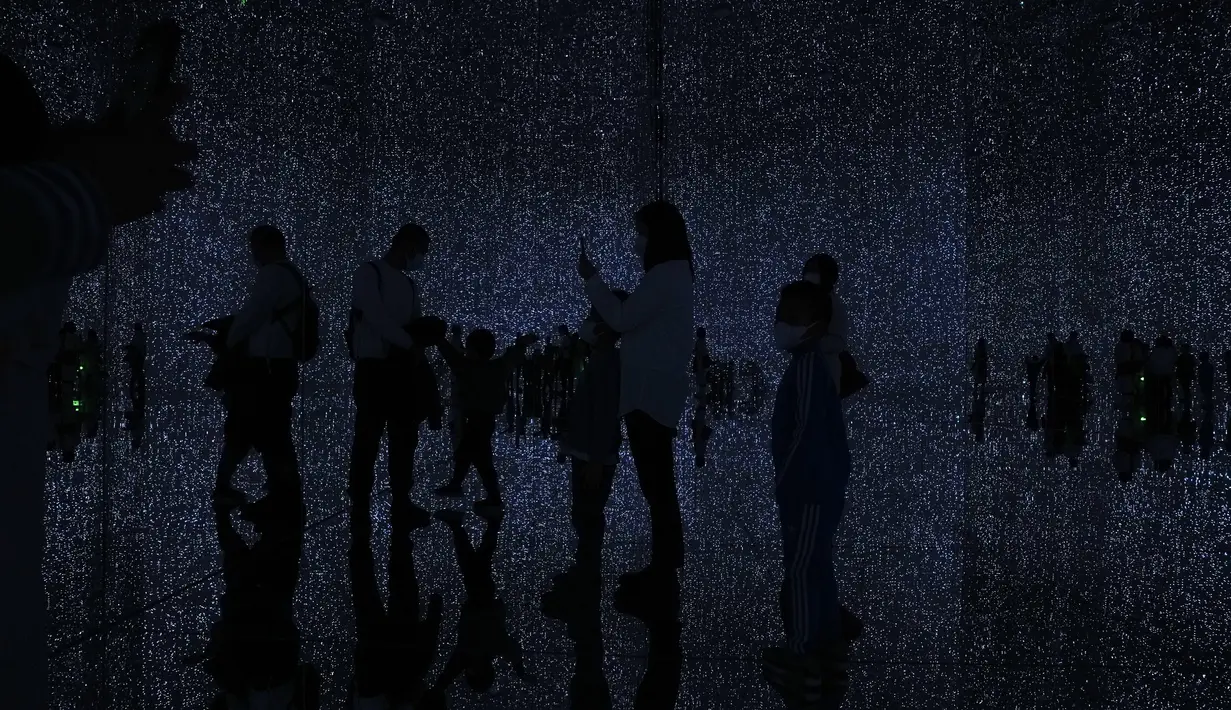 Siluet pengunjung saat menikmati instalasi seni digital imersif berjudul "The Infinite Crystal Universe", di museum "teamLab Massless" yang baru dibuka di Beijing, China, Senin (26/12/2022). Berbasis di Tokyo teamLab membuat museum seni digital yang memamerkan berbagai karya seni interaktif di dalam pusat perbelanjaan di ibu kota Beijing. (AP Photo/Andy Wong)