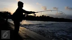 Warga memancing di tepian Pantai Teluk Penyu Kabupaten Cilacap, Jawa Tengah,Jumat (29/7). Pantai Teluk Penyu terletak di kecamatan Cilacap Selatan dengan jarak 2 km dari pusat kota. (Liputan6.com/Helmi Afandi)