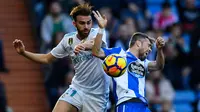 Pemain Real Madrid, Borja Mayoral berebut bola dengan pemain Deportivo La Coruna, Luisinho dalam lanjutan La Liga Spanyol di Santiago Bernabue, Senin (22/1). Real Madrid membukukan kemenangan 7-1 atas Deportivo La Coruna. (OSCAR DEL POZO/AFP)