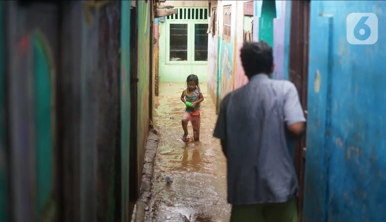 Warga beraktivitas di tengah banjir yang merendam kawasan Rawajati, Jakarta Selatan, Sabtu (8/2/2020). Hujan yang terjadi semalaman menyebabkan Sungai Ciliwung kembali meluap hingga membuat rumah warga di kawasan tersebut terendam air setinggi 50 cm hingga 1 m. (Liputan6.com/Immanuel Antonius)