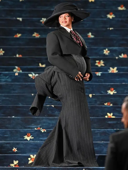Ini menjadi penampilan perdana Rihanna yang sedang mengandung anak ketiganya dengan A$AP Rocky di Met Gala 2025. (Andrea RENAULT/AFP)