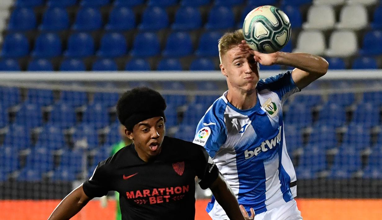Bek Sevilla, Jules Kounde, berebut bola dengan striker Leganes, Manu Garrido, pada laga lanjutan La Liga pekan ke-33 di Estadio Municipal de Butarque, Rabu (1/7/2020) dini hari WIB. Sevilla menang 3-0 atas Leganes. (AFP/Pierre-Philippe Marcou)