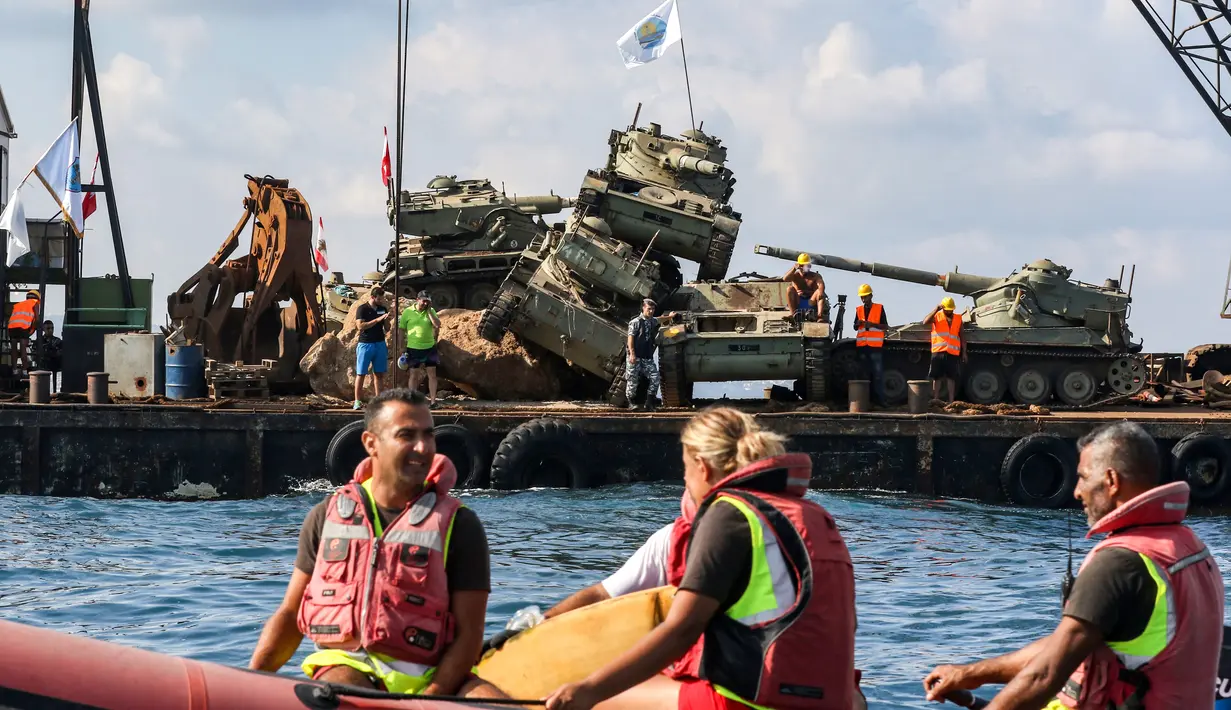 Aktivis lingkungan menurunkan tank lama ke dasar Laut Mediterania di lepas pantai kota pelabuhan Sidon, Lebanon, Sabtu (28/7). Mereka menenggelamkan 10 tank lama yang yang merupakan hadiah  dari Angkatan Bersenjata Lebanon. (AFP / Mahmoud ZAYYAT)