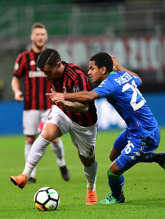 Pemain depan AC Milan, Fernandez Suso berebut bola dengan bek Sassuolo, Rogerio pada laga pekan ke-31 Serie A di San Siro, Minggu (8/4). Menjamu Sassuolo, AC Milan gagal meraih kemenangan usai hanya bermain imbang 1-1. (AFP PHOTO/MIGUEL MEDINA)