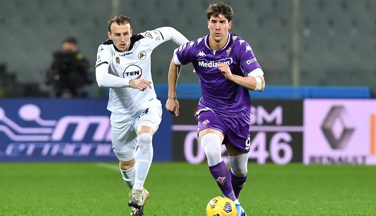 Striker Fiorentina, Dusan Vlahovic (kanan) menguasai bola dibayangi gelandang Spezia, Nahuel Estevez dalam laga lanjutan Liga Italia 2020/21 pekan ke-23 di Artemio Franchi Stadium, Jumat (19/2/2021). Fiorentina menang 3-0 atas Spezia. (LaPresse via AP/Jennifer Lorenzini)