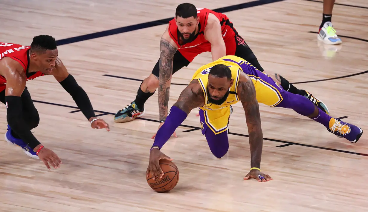 Pebasket LA Lakers, LeBron James, berebut bola dengan pebasket Houston Rockets pada semifinal playoff NBA di ESPN Wide World Sports, Orlando, Jumat (11/9/2020). LA Lakers menang 110-100 atas Houston Rockets. (AFP/Michael Reaves/Getty Images)