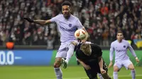 Penyerang Barcelona Pierre-Emerick Aubameyang berebut bola dengan bek Eintracht Frankfurt Martin Hinteregger pada laga leg pertama perempat final Liga Europa 2021/22 di Deutsche Bank Park, Jumat dini hari WIB (8/4/2022). (AP Photo/Michael Probst)