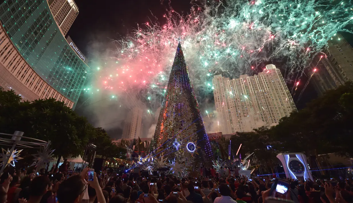 Pohon Natal setinggi 38 meter berdiri di salah satu pusat perbelanjaan di Jakarta (25/12/2015). Pesta kembang api menjadikan malam Natal di Jakarta semakin meriah. (AFP Photo/Adek Berry)