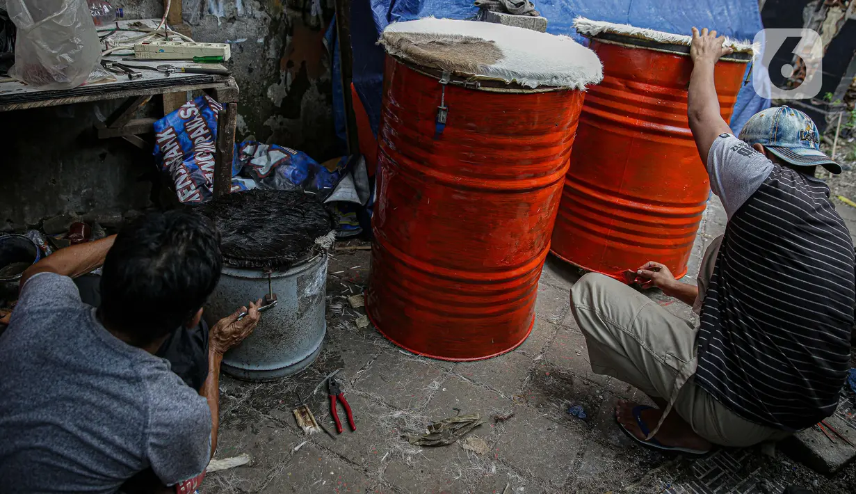 Pekerja menyelesaikan pembuatan bedug di jalan KH Mas Mansyur, Tanah Abang, Jakarta, Senin (10/6/2021). Menjelang Idul Fitri 1442 H, pedagang bedug di sepanjang jalan itu mulai ramai menjajakan dagangannya dari harga 40 ribu hingga Rp 2,5 juta. (Liputan6.com/Faizal Fanani)