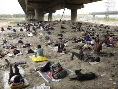 Para tunawisma tidur di bawah naungan jembatan layang pada hari yang panas di New Delhi, Jumat (20/5/2022). Ibu kota India dan sekitarnya tengah menghadapi kondisi gelombang panas yang ekstrem. (AP Photo/Manish Swarup)