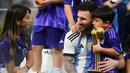 Pemain Argentina, Lionel Messi merayakan kemenangan timnya di Piala Dunia 2022 bersama keluarganya setelah mengalahkan Prancis pada laga final yang berlangsung di Lusail Stadium, Qatar, Minggu (18/12/2022). Albiceleste menang 4-2 atas Prancis di babak penalti. (AP Photo/Manu Fernandez)