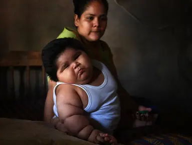 Bayi berusia sepuluh bulan bernama Luis Gonzales bersama ibunya, Isabel Pantoja di rumah mereka di Tecoman, negara bagian Colima, Meksiko (8/11). (AFP Photo/Pedro Pardo)
